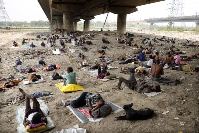 Homeless people sleep in the shade of an overbridge on a hot day in New Delhi, Friday, May 20, 2022. The Indian capital and surrounding areas are facing extreme heat wave conditions. (Photo by Manish Swarup/AP Photo)