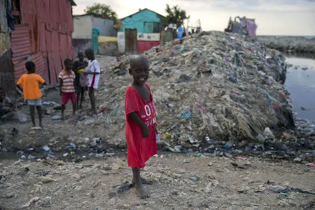 In this December 3, 2019 photo, a boy stands near an open sewage canal in Cite Soleil slum of Port-au-Prince, Haiti. The boys was flying a kite along with his friends. The United Nations recently said 3.7 million people are facing emergency levels of food insecurity, including 1 million who are at stage four, one level below famine. (Photo by Dieu Nalio Chery/AP Photo)