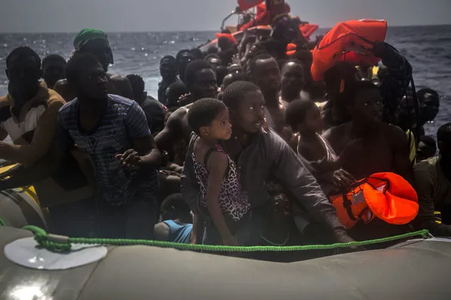 Migrants wait to be rescued by aid workers of Spanish NGO Proactiva Open Arms in the Mediterranean Sea, about 15 miles north of Sabratha, Libya on Tuesday, July 25, 2017. (Photo by Santi Palacios/AP Photo)