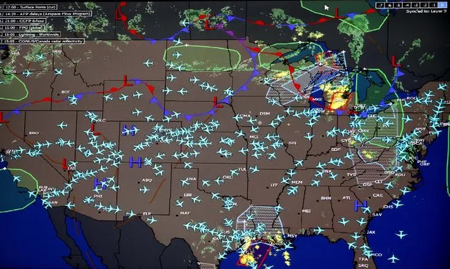 A U.S. map shows the active United Airline flights in the air on a large display monitor at United Airline's new Network Operations Center in Chicago June 18, 2012