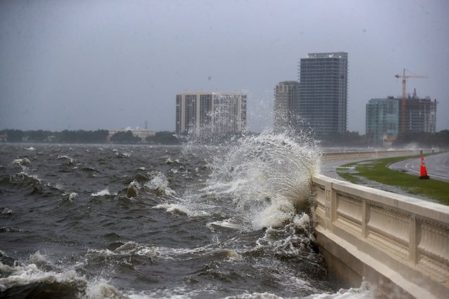 A wave crashes the balustrade along Bayshore Boulevard where a stretch of road is closed due to flooding from incoming high tide while Tropical Storm Debby approaches the gulf coast, in Tampa, Florida on August 4, 2024. (Photo by Octavio Jones/Reuters)