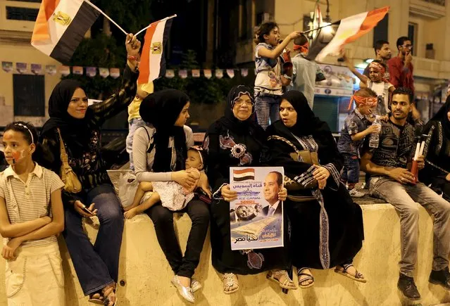 A woman holds a banner with picture of President Abdel Fattah al-Sisi as people gather in Tahrir square to celebrate an extension of the Suez Canal, in Cairo, Egypt, August 6, 2015. (Photo by Asmaa Waguih/Reuters)