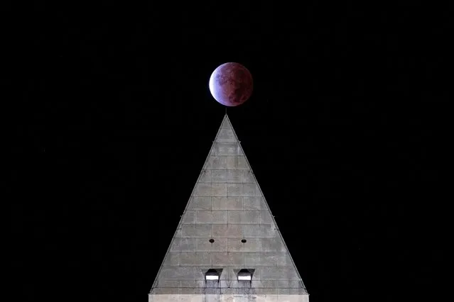 The Beaver “blood” Moon partial lunar eclipse is seen above the Washington Monument in Washington, U.S. November 19, 2021. (Photo by Al Drago/Reuters)