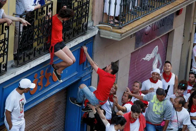A reveller climbs on to a balcony before the start of Fuente Ymbro's fighting bulls running during the second day of the San Fermin Running of the Bulls festival on July 7, 2016 in Pamplona, Spain. (Photo by Pablo Blazquez Dominguez/Getty Images)