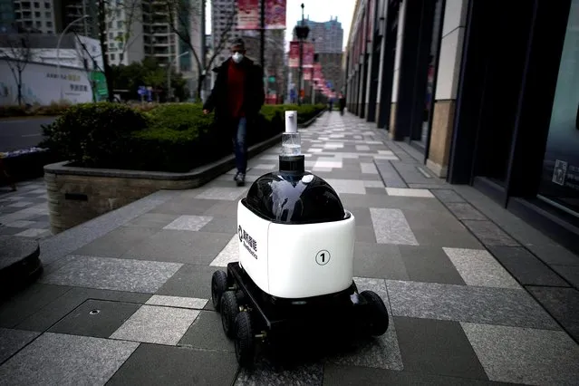 A robot with a dispenser for hand sanitizer goes around a shopping complex as the country is hit by an outbreak of the novel coronavirus, in Shanghai, China on March 4, 2020. (Photo by Aly Song/Reuters)