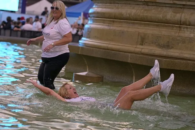 England supporters celebrate in a fountain in Trafalgar Square after watching their team win the final of the Women's Euro 2022 soccer match between England and Germany being played at Wembley stadium in London, Sunday, July 31, 2022. (Photo by Frank Augstein/AP Photo)