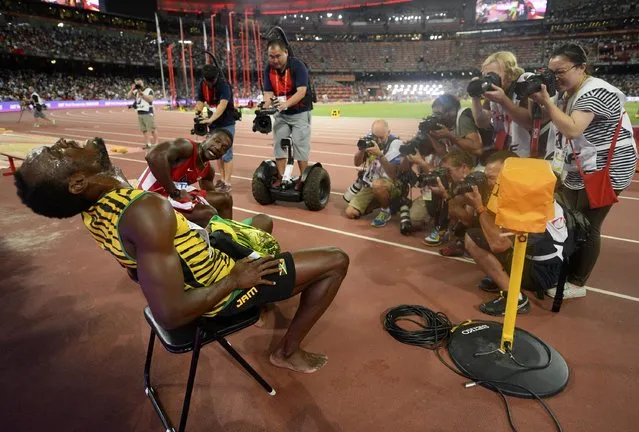 Usain Bolt of Jamaica (L) poses for photographers after winning the men's 200 metres final as Justin Gatlin from the U.S. looks on during the 15th IAAF World Championships at the National Stadium in Beijing, China, August 27, 2015. (Photo by Dylan Martinez/Reuters)