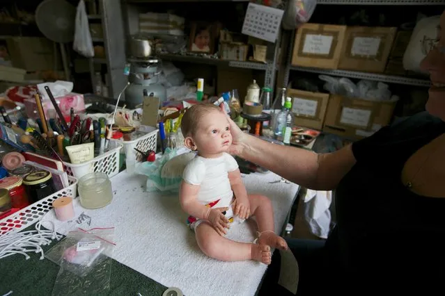 A damaged doll is pictured on a workbench after having its head re-attached by 25-year veteran doll repairer Kerry Stuart at Sydney's Doll Hospital, July 15, 2014. Opened in 1913, Sydney's Doll Hospital has worked on millions of dolls, teddy bears and other toys. (Photo by Jason Reed/Reuters)