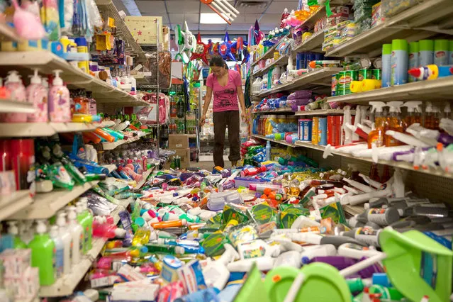 Nina Quidit cleans up the Dollar Plus and Party Supplies Store in American Canyon Calif. after an earthquake on Sunday Aug. 24, 2014. Quidit and her husband were woken up in the early morning hours by the store's alarm company and immediately drove in to begin clean up. The 6.0-magnitude quake caused six significant fires, including at four mobile homes, Napa Division Fire Chief Darren Drake said. (Photo by Alex Washburn/AP Photo)