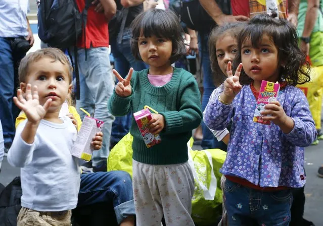 Migrants' children gesture near the Keleti railway station in Budapest, Hungary, September 3, 2015. Over 2,000 migrants, many of them refugees from conflicts in the Middle East and Africa, had been camped in front of the Keleti Railway Terminus, closed to them by authorities saying European Union rules bar travel by those without valid documents. (Photo by Leonhard Foeger/Reuters)