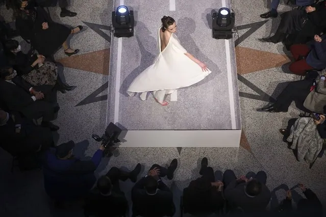 A model takes to the catwalk inside the 19th century building City Hall in Sarajevo, Bosnia, Thursday, December 16, 2021, during the presentation of a collection dubbed “No Nation Fashion”, a migrant-made fashion brand project. (Photo by AP Photo/Stringer)