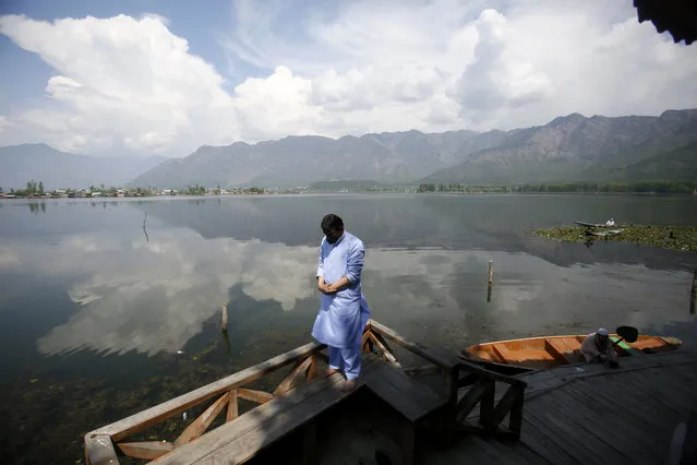 A Kashmiri Muslim man offers prayer on the banks of Dal Lake on the second day of Ramadan during lockdown to prevent the spread of the new coronavirus in Srinagar, Indian controlled Kashmir, Sunday, April 26, 2020. Kashmiri shrines that are usually packed with devotees during the holy month of Ramadan wore a deserted look Sunday as authorities closed the shrine for the safety of the public. (Photo by Mukhtar Khan/AP Photo)