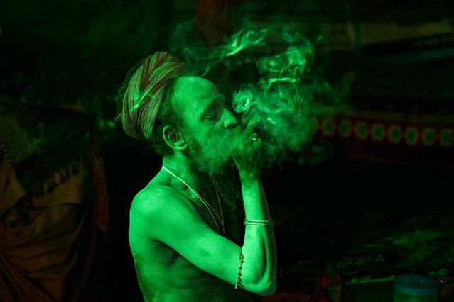 A Sadhu or Hindu holy man smokes a “chillum”, a traditional clay pipe, at a camp in Prayagraj on January 3, 2025, ahead of the Maha Kumbh Mela festival. (Photo by Niharika Kulkarni/AFP Photo)