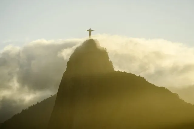 The “Christ the Redeemer” statue is partly covered by clouds in Rio de Janeiro, Brazil, 31 July 2016. The Rio 2016 Olympic Games start on 05 August. (Photo by Lukas Coch/EPA)