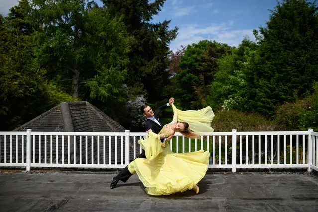 Ballroom dancers Roman Sukhomlyn and India Phillips, the North of England Champions at the British National Dance Championships, practice on their balcony at home during the lockdown due to the novel coronavirus pandemic, in Wolverhampton, central England on May 7, 2020. Roman Sukhomlyn and India Phillips normally split their time between the UK and Ukraine. When in the UK they would train off-site at least a couple of times a week at dance schools in the area. Now during the lockdown the couple are concentrating all their time practicing in their home studio in Wolverhampton to prepare for the Blackpool Dance Festival 2020, which due to the pandemic has been been provisionally rearranged from its usual May date to take place between August 25 and September 6. (Photo by Oli Scarff/AFP Photo)