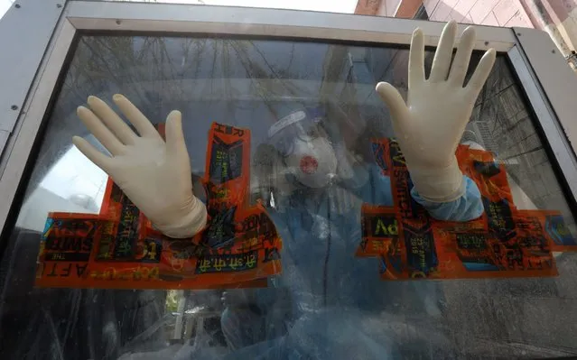 A Medical staff member sitting inside a Mobile Covid-19 Testing van gets his protective gloves sanitized as he collects swab samples for testing at red zone area of Jammu, India, 11 May 2020. According to the news reports, 25 new coronavirus positive cases were reported on 11 May. The Indian government announced lockdown extension for two weeks until 17 May, with new relaxation action plan for Red, Orange and Green Zones but people still seeking clarity from local authorities as the third phase of the countrywide lockdown begins to stem the widespread of the SARS-CoV-2 coronavirus. (Photo by Jaipal Singh/EPA/EFE/Rex Features/Shutterstock)