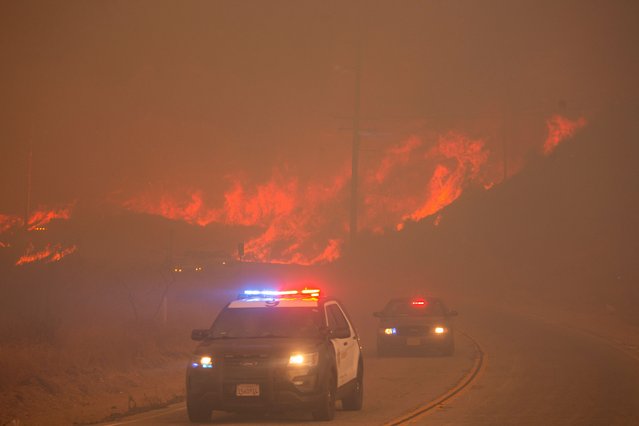 Law enforcement vehicles drive by as the Hughes Fire burns near Castaic Lake, north of Santa Clarita, California, on January 22, 2025. (Photo by Ringo Chiu/Reuters)