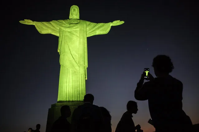 Visitors stand under the Christ the Redeemer statue on Corcovado mountain ahead of the Rio 2016 Olympic Games in Rio de Janeiro on August 4, 2016. (Photo by Jeff Pachoud/AFP Photo)