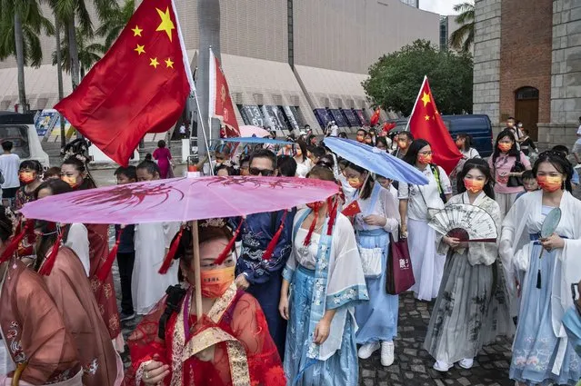 People dressed in Han dynasty costumes hold Chinese flags during China's National Day in Hong Kong, China, 01 October 2022. (Photo by Miguel Candela/EPA/EFE)