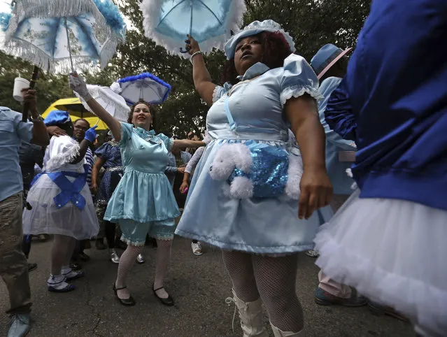 Members of the Baby Dolls, a traditional Mardi Gras social club, dance during a second line parade honoring music legend Fats Domino, in New Orleans, Wednesday, November 1, 2017. The thousand-strong group marched and danced from Vaughn's Lounge to Domino's former home in the Lower 9th Ward. Domino, a New Orleans native, died this past week. (Photo by Gerald Herbert/AP Photo)