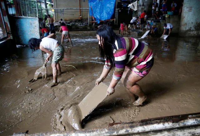 Residents remove mud brought by flooding from monsoon rains at an evacuation centre in San Mateo, Rizal, Philippines, August 14, 2016. (Photo by Erik De Castro/Reuters)