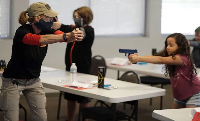A retired Butte County sheriff’s office deputy teaches gun safety to a nine year-old at a summer camp in New Mexico on June 24, 2020. (Photo by Adolphe Pierre-Louis/Albuquerque Journal/ZUMA Press/Rex Features/Shutterstock)