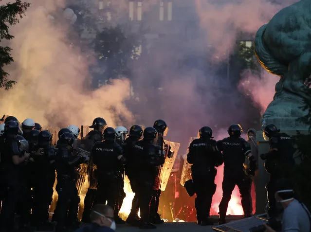 Serbian riot police clashes with protesters in Belgrade, Serbia, Wednesday, July 8, 2020. Serbia's president Aleksandar Vucic backtracked Wednesday on his plans to reinstate a coronavirus lockdown in Belgrade after thousands protested the move and violently clashed with the police in the capital. (Photo by Darko Vojinovic/AP Photo)