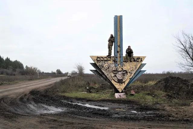 Ukrainian servicemen stand and sit on a structure trying to catch mobile network near the borders of the Kharkiv and Donetsk regions of Ukraine on November 10, 2022, amid the Russian invasion of Ukraine. (Photo by Ihor Tkachov/AFP Photo)