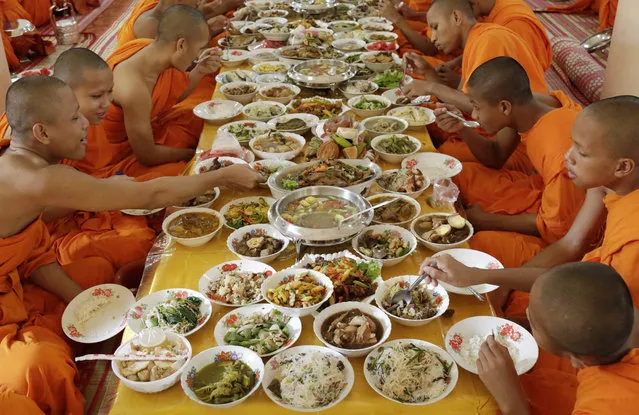 Cambodian Buddhist monks enjoy their lunch during the Day of the Dead (Ancestors' Day), at a pagoda in Phnom Penh, Cambodia, 28 September 2015. Cambodia celebrates the Festival of Death from 28 September to 12 October 2015. During these 15 days, many Cambodians go to pagodas, bring food and other offerings to Buddhist monks and visit their families. (Photo by Mak Remissa/EPA)