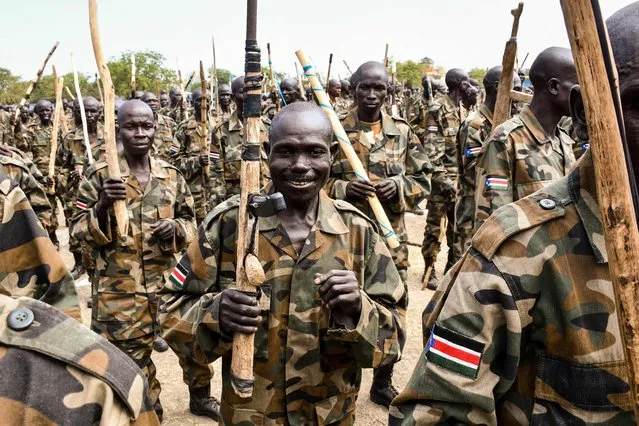 New members of South Sudan People's Defence Forces (SSPDF) of the Unified Forces attend with handmade wooden rifles or sticks during the graduation ceremony in Malakal on November 21, 2022. About nine thousand members including former soldiers of rebels in South Sudan's civil war were integrated into the country's Unified Forces after more than 3 years of training since the implementation of the revitalized peace agreement in 2018. (Photo by Samir Bol/AFP Photo)