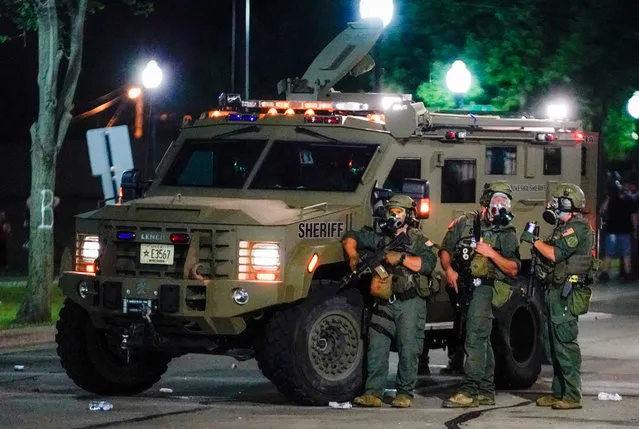 Law enforcement officers face angry crowds during a second night of unrest in the wake of the shooting of Jacob Blake by police officers, in Kenosha, Wisconsin, USA, 24 August 2020. (Photo by Tannen Maury/EPA/EFE)