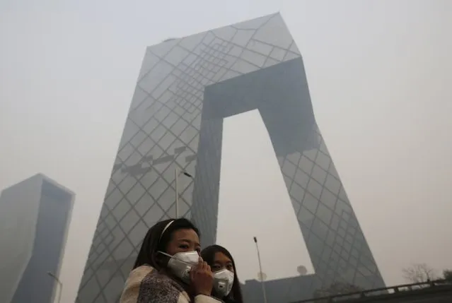 Women wearing face masks walk during a heavily hazy day in Beijing, November 19, 2014. (Photo by Kim Kyung-Hoon/Reuters)