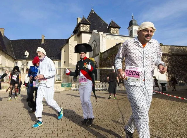 Costumed competitors, including a man dressed as Napoleon, run during the Marathon International du Beaujolais race at the castle of Pizay, November 22, 2014. (Photo by Robert Pratta/Reuters)