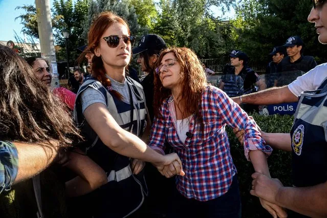 Turkish police officers arrest a teacher during a demonstration to protest against the suspension of teachers for suspected links with militants, on September 24, 2016 in Diyarbakir. Turkey on September 8, 2016 suspended teachers suspected of having engaged in activities in support of the outlawed Kurdistan Workers' Party (PKK) listed as a terror group by Ankara and its Western allies. Turkish schools reopened September 19 for the first time since the July 15 coup following a summer which saw tens of thousands of teachers sacked or suspended over “links” to the plotters or to Kurdish rebels. (Photo by Ilyas Akengin/AFP Photo)