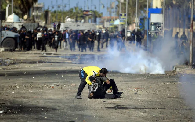 An Egyptian protester evacuates a wounded man during clashes between protesters and riot police near the state security building in Port Said, Egypt, Wednesday, March 6, 2013. Clashes between protesters and police have broken out in this restive Egyptian port city despite efforts by the military to separate the two sides. (Photo by Khalil Hamra/AP Photo)