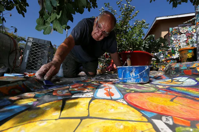 Artist Gonzalo Duran lays a tile walkway at his home, the Mosaic Tile House in Venice, California U.S., September 1, 2016. (Photo by Mario Anzuoni/Reuters)