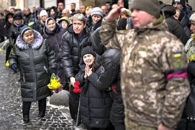 Anastasia, center, cries as soldiers carry the coffin of her brother Oleg Kunynets, a Ukrainian military servicemen who were killed in the east of the country, during his funeral in Lviv, Ukraine, Tuesday, February 7, 2023. (Photo by Emilio Morenatti/AP Photo)