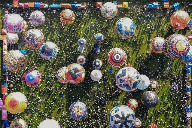 An aerial image shows hot air balloons, mostly made from recycled paper and tied with ropes, floating in the air during the annual hot air balloon festival, held since 1950 to celebrate Eid al-Fitr, the Islamic holiday marking the end of Ramadan, in Wonosobo, Central Java, on April 2, 2025. (Photo by Devi Rahman/AFP Photo)