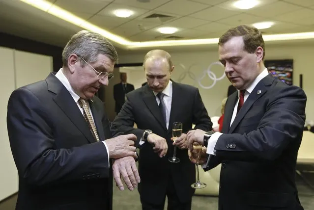 Russia's President Vladimir Putin (C), Prime Minister Dmitry Medvedev (R) and International Olympic Committee (IOC) President Thomas Bach of Germany check their watches before the closing ceremony of the 2014 Sochi Winter Olympics, in this February 23, 2014 file photo. (Photo by Dmitry Astakhov/Reuters/RIA Novosti)