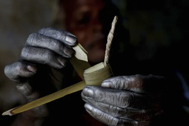 An Indian village man folds palm leaves as he makes firecrackers with bare hands at his workshop at Bhingharpur village, outskirts of Bhubaneswar, Orissa state, India, Monday, November 2, 2015. Fire crackers are in high demand in India during the upcoming festival of lights, “Diwali”. (Photo by Biswaranjan Rout/AP Photo)