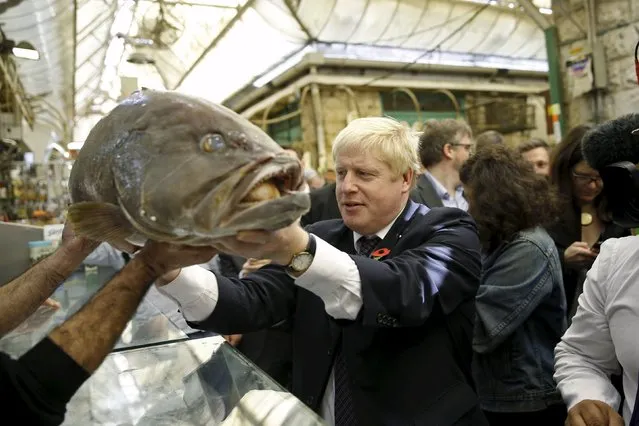 London's mayor Boris Johnson holds a fish while touring the Mahane Yehuda market in Jerusalem November 10, 2015. (Photo by Ronen Zvulun/Reuters)