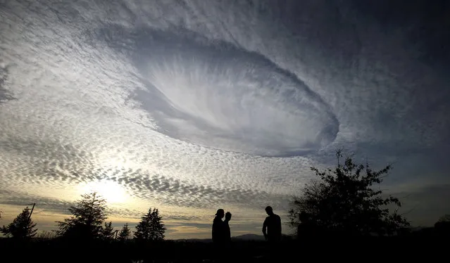 Cloud patterns converge above the East Park Skate Park in Bremerton, Wash., on Wednesday, December 13, 2017. A rare fallstreak hole is in the middle. (Photo by Larry Steagall/Kitsap Sun via AP Photo)