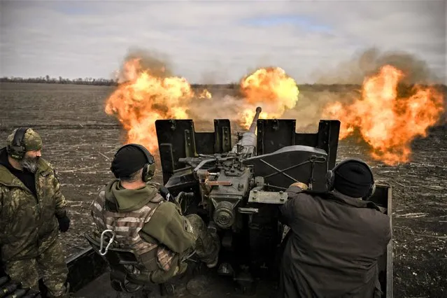 Ukrainian servicemen fire with a S60 anti-aircraft gun at Russian positions near Bachmut on March 20, 2023, amid the Russian invasion of Ukraine. (Photo by Aris Messinis/AFP Photo)