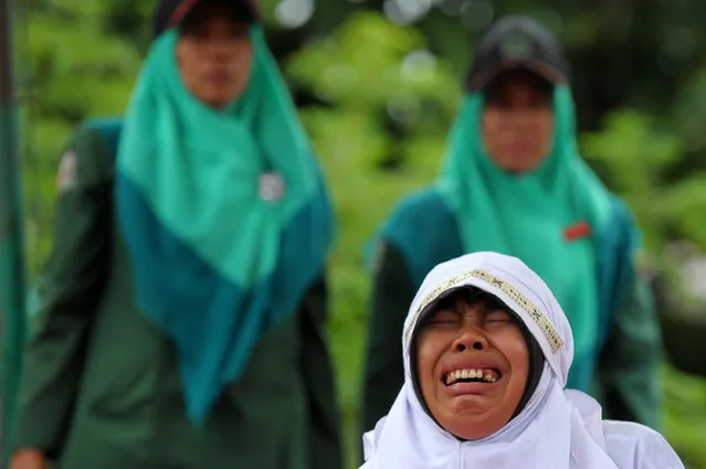 A Muslim girl cries out as she gets caned 23 strokes after being caught in close proximity with her boyfriend in Banda Aceh on October 17, 2016. (Photo by Chaideer Mahyuddin/AFP Photo)