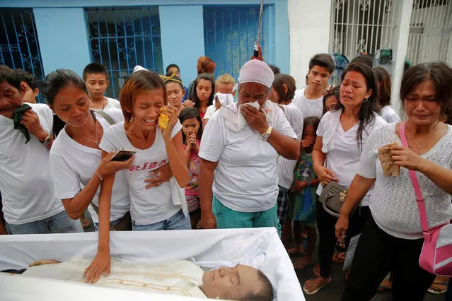 Diane Agregado, the daughter, and other relatives of Reynaldo Agregado, who was killed in a police anti-drugs operation, mourn over his body during the funeral in Manila, Philippines October 15, 2016. (Photo by Damir Sagolj/Reuters)