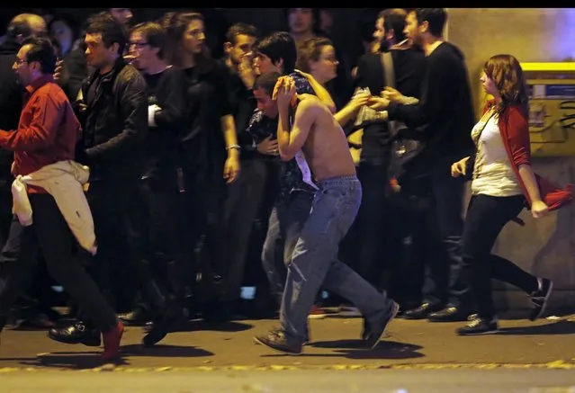 An injured man holds his head as people gather near the Bataclan concert hall following fatal shootings in Paris, France, November 13, 2015. (Photo by Christian Hartmann/Reuters)