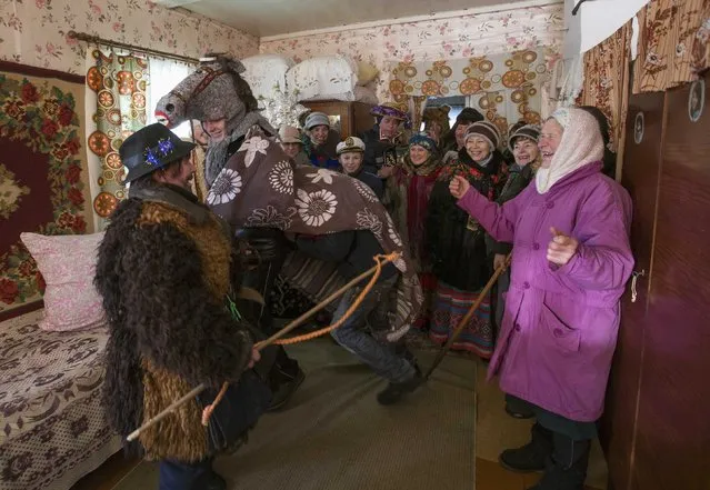 People celebrate the pagan rite called “Kolyadki” in the village of Osovo, east of Minsk, January 7, 2015. Kolyada is a pagan winter holiday, which over the centuries has merged with Orthodox Christmas celebrations in Ukraine and some parts of Belarus. (Photo by Vasily Fedosenko/Reuters)