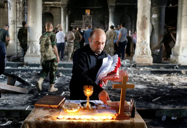 An Iraqi Christian prepares for the first Sunday mass at the Grand Immaculate Church since it was recaptured from Islamic State in Qaraqosh, near Mosul in Iraq October 30, 2016. (Photo by Ahmed Jadallah/Reuters)