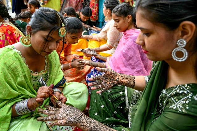College girls decorate their hands with henna to celebrate the Hindu festival of Teej at Shahzada Nand college in Amritsar, India on August 3, 2024. (Photo by Narinder Nanu/AFP Photo)