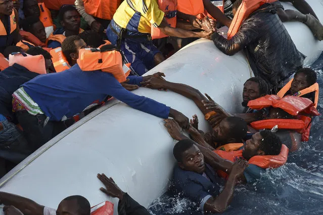 Migrants and refugees panic as they fall in the water during a rescue operation of the Topaz Responder rescue ship run by Maltese NGO Moas and Italian Red Cross, off the Libyan coast in the  Mediterranean Sea, on November 3, 2016. (Photo by Andreas Solaro/AFP Photo)
